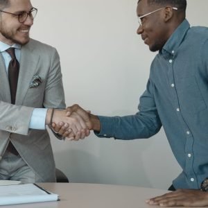 pexels-photo-5439453-5439453 Two men shaking hands during a professional business meeting in a modern office.